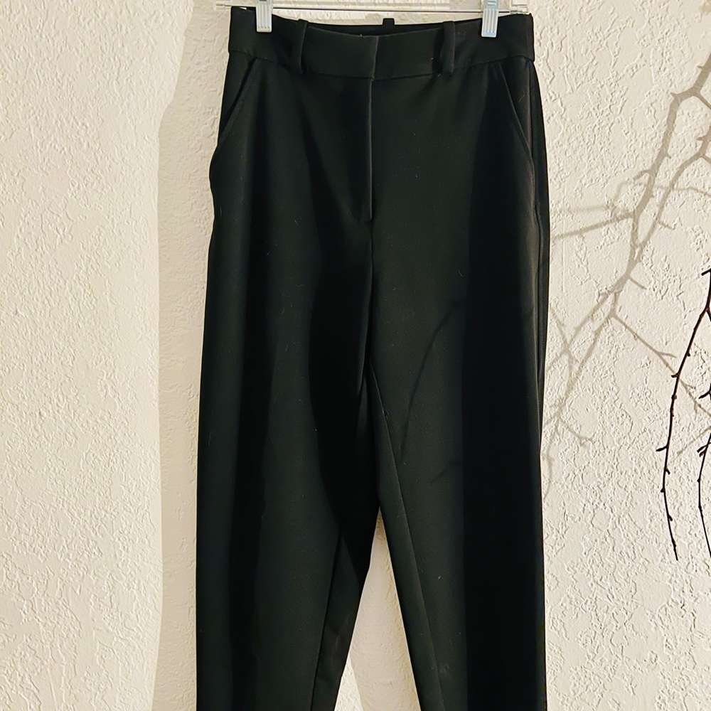 Black slack. Double hinge waist, belt loop, slight flare at the bottom.